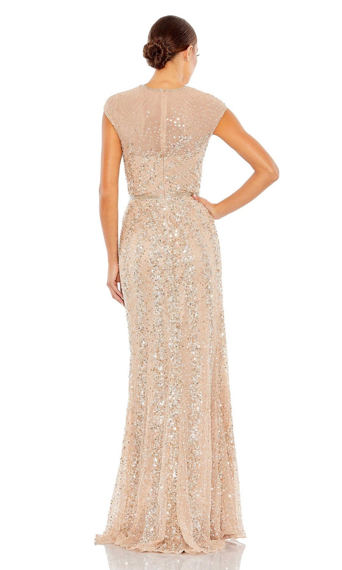 A woman faces away, wearing the Mac Duggal 5619 Sleeveless Beaded Long Formal Dress, featuring a floor-length nude design with shimmering beads and a fitted waist.